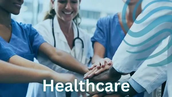 Team of four Doctors and Nurses in scrubs and laboratory coats huddled with their hands in the middle indicating a teamwork environment in a medical setting with the Specialized Recruiting Group Logo and the word Healthcare written over the top of the image