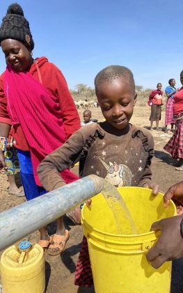 Boy in Kenya fills bucket with water