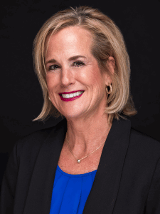 Professional photo of Darcy dressed in professional attire. Darcy is a middle-aged woman with blonde hair. 